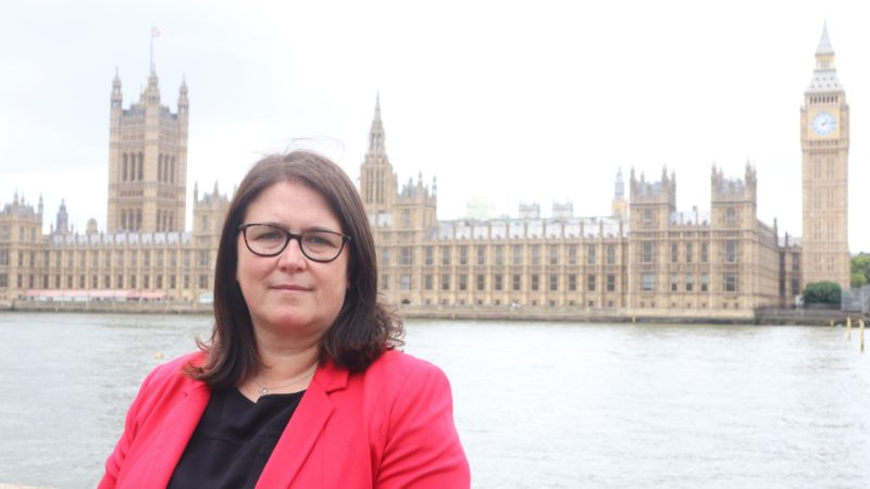 Rachel Hopkins MP in front of Parliament in red jacket